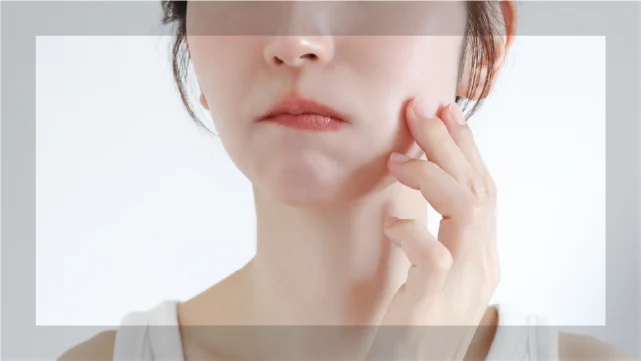 頬の毛穴や皮脂の悩みを気にする女性の顔のアップ