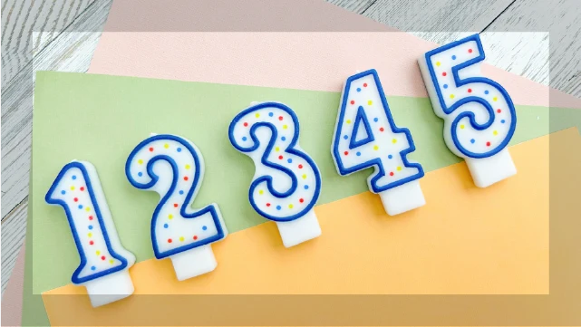 パステルカラーの背景に並べられた数字の1から5のキャンドル